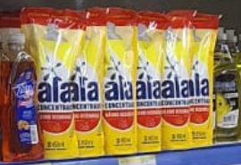 Six yellow Ala detergent sachets standing side by side on a blue shelf